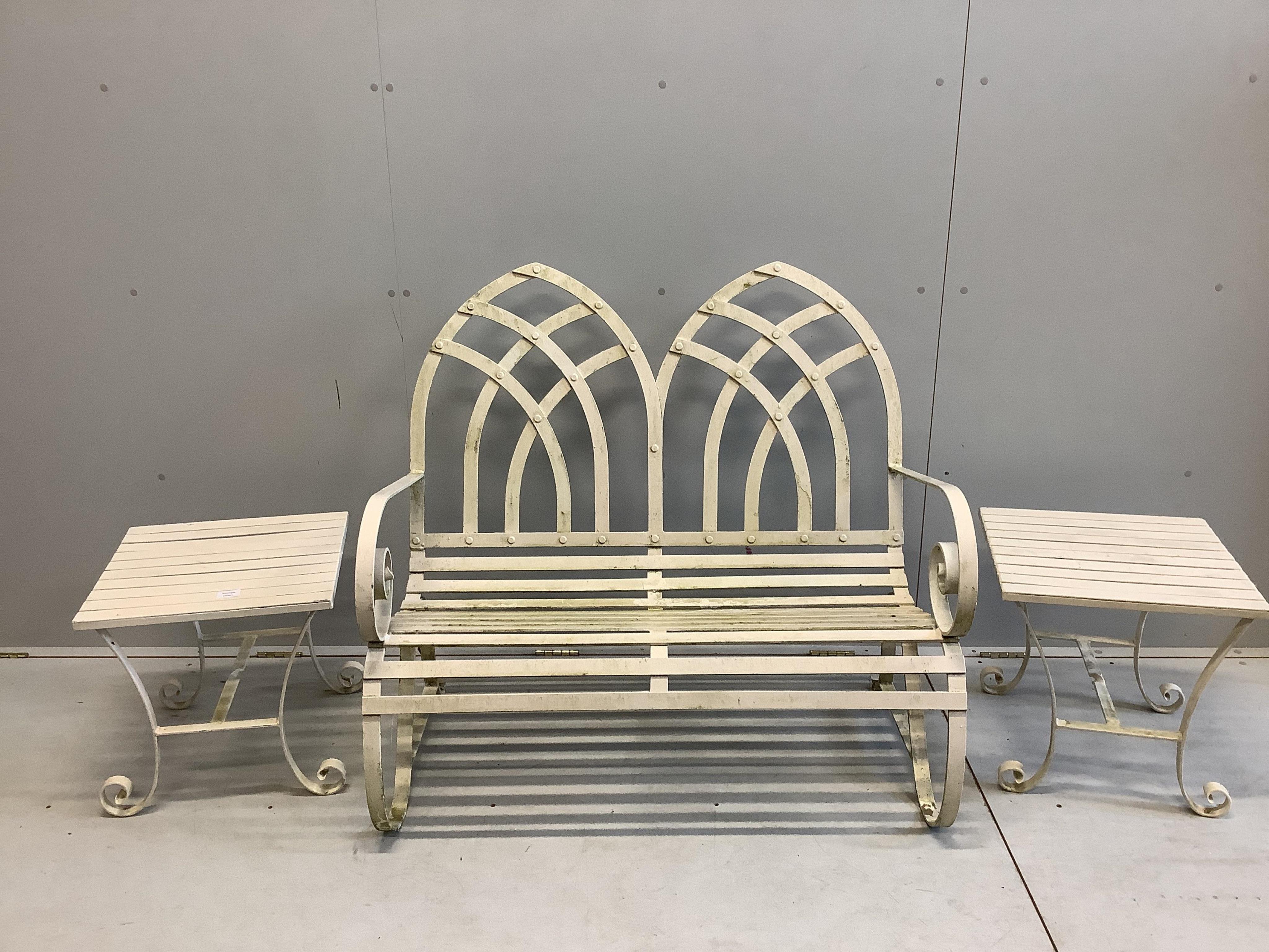 A Camelia Botnar Gothic style wrought iron garden bench, width 106cm, depth 61cm, height 99cm together with a pair of wrought iron square garden tables and a canvas parasol with cast metal base. Condition - fair